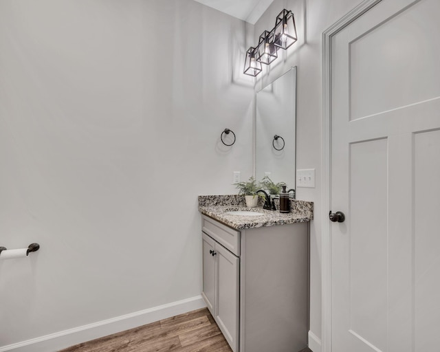 bathroom with vanity, baseboards, and wood finished floors