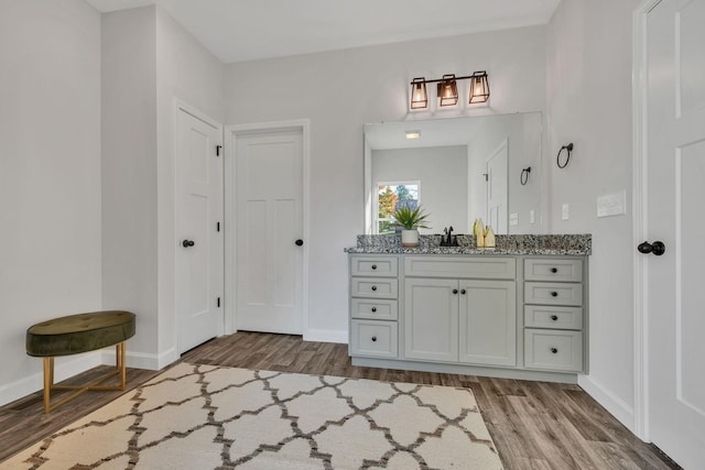 bathroom featuring baseboards, wood finished floors, and vanity