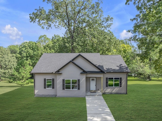 view of front of home featuring roof with shingles and a front yard