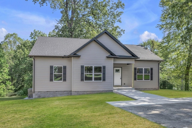 view of front of property with driveway, a shingled roof, and a front lawn