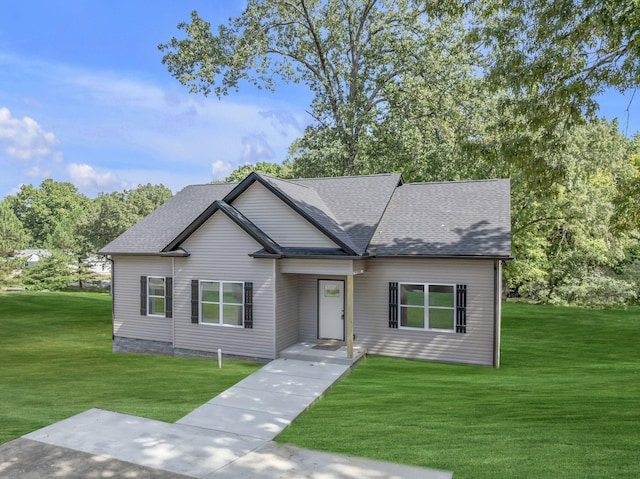 view of front of home with roof with shingles and a front yard