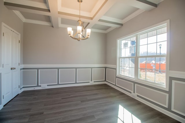 unfurnished dining area featuring dark wood finished floors, coffered ceiling, a wainscoted wall, an inviting chandelier, and beam ceiling