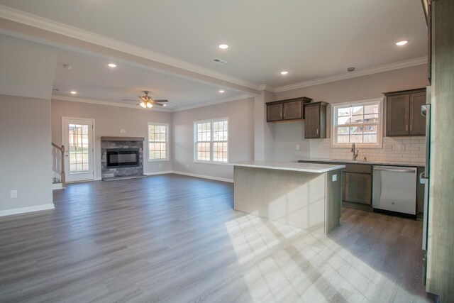 kitchen with dishwasher, a healthy amount of sunlight, wood finished floors, and decorative backsplash