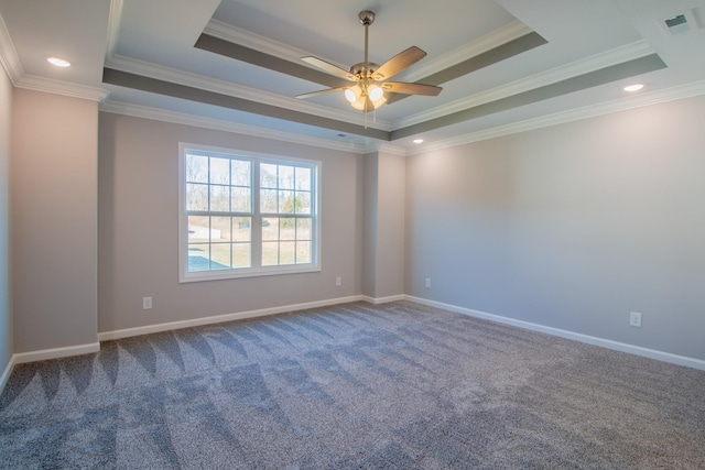 empty room with crown molding, a tray ceiling, carpet flooring, and baseboards