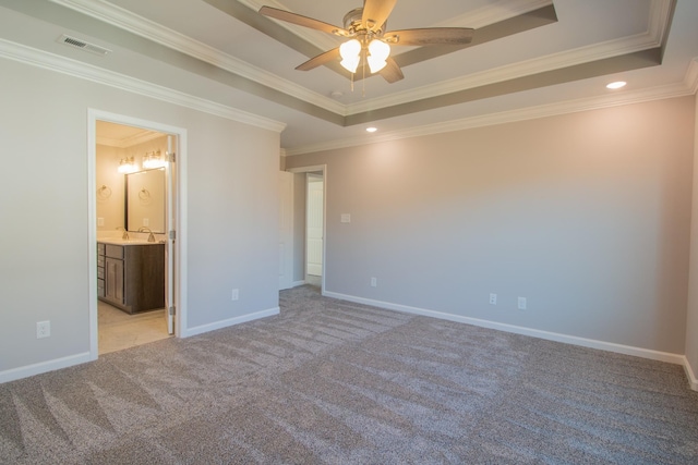 unfurnished bedroom featuring light carpet, a tray ceiling, visible vents, and baseboards