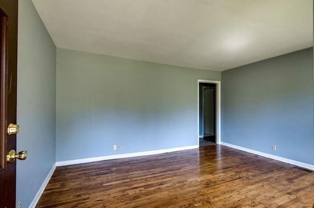 unfurnished room with visible vents, baseboards, and wood finished floors