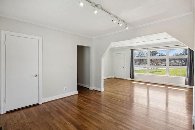 additional living space featuring baseboards and wood finished floors