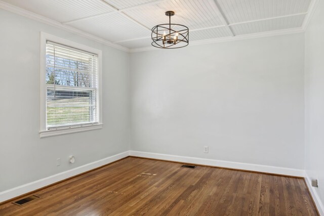 unfurnished room featuring dark wood-style flooring, visible vents, ornamental molding, a chandelier, and baseboards