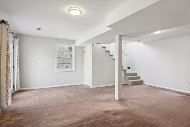 below grade area with stairway, carpet flooring, and baseboards