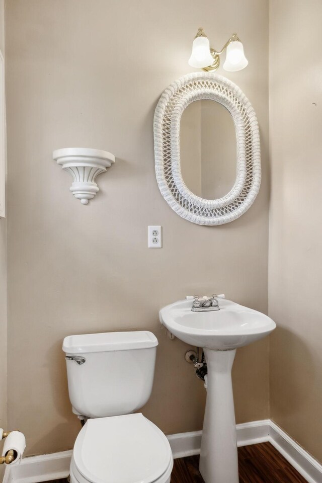 bathroom featuring toilet, baseboards, and wood finished floors