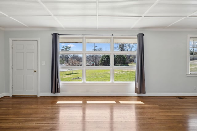 spare room with plenty of natural light, baseboards, and wood finished floors