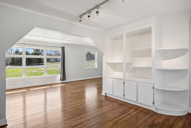 additional living space featuring a textured ceiling, baseboards, and wood finished floors