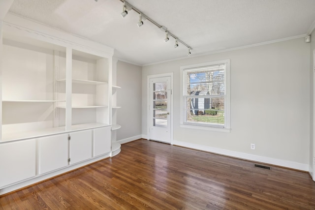 unfurnished room with ornamental molding, wood finished floors, visible vents, and baseboards