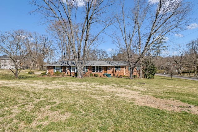 view of front of home with brick siding and a front lawn