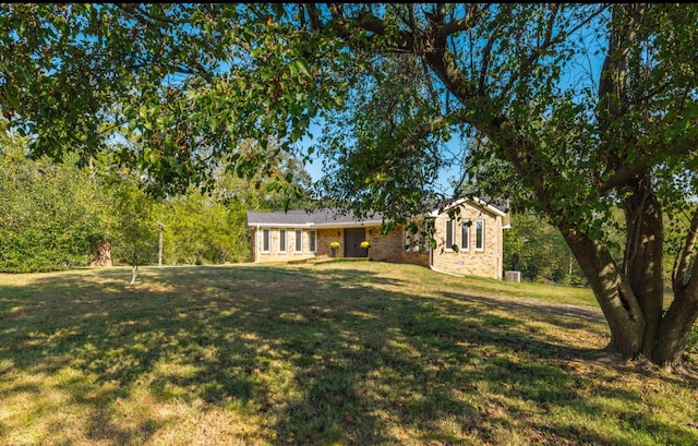 ranch-style house featuring brick siding and a front yard