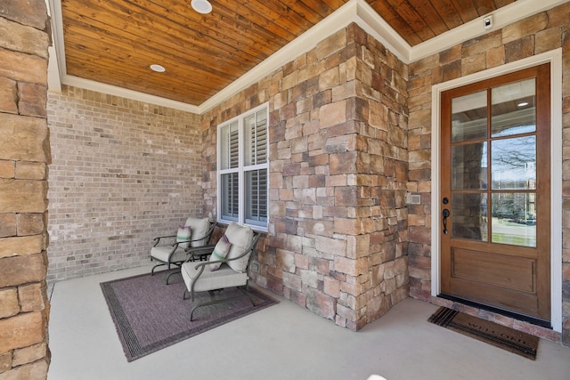 entrance to property featuring covered porch and brick siding