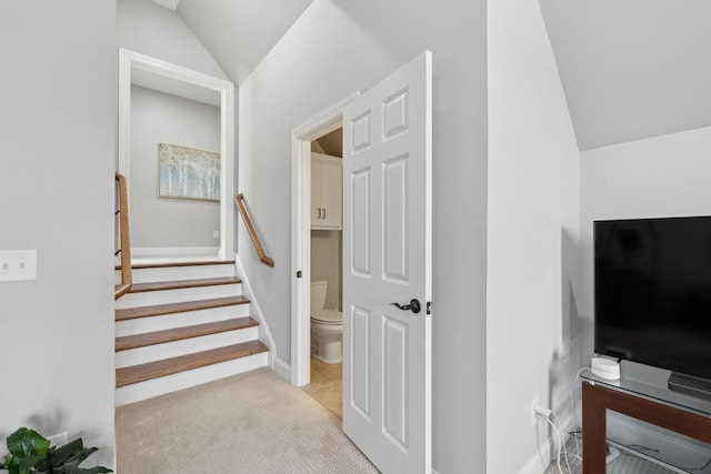 staircase with carpet floors and vaulted ceiling