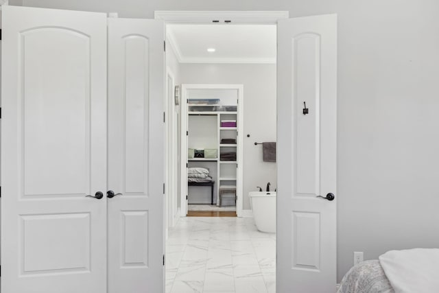 bedroom with marble finish floor, ornamental molding, a spacious closet, and a closet