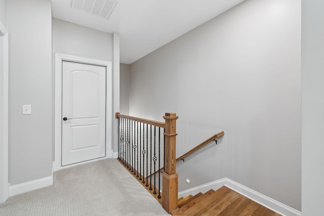 stairway with carpet floors, baseboards, and visible vents