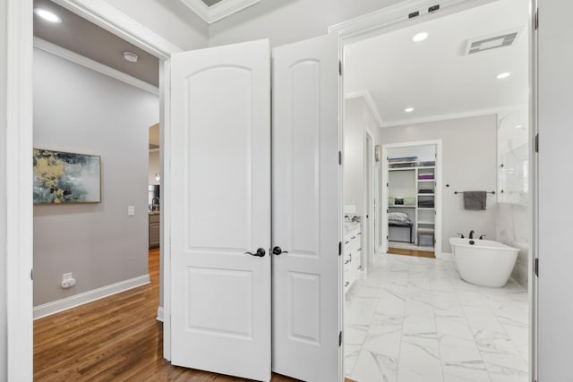 full bathroom featuring baseboards, visible vents, ornamental molding, marble finish floor, and a freestanding tub