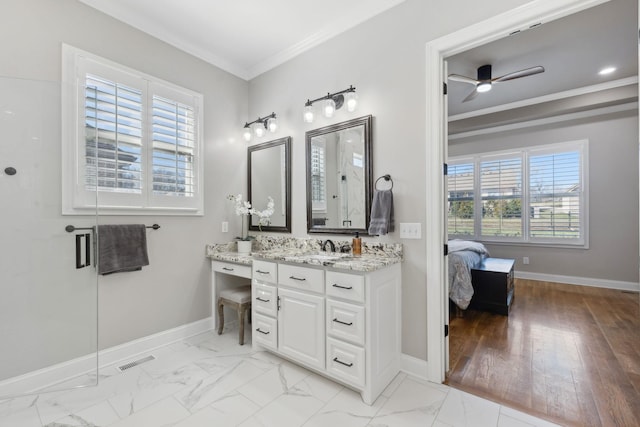 ensuite bathroom with marble finish floor, plenty of natural light, and ornamental molding