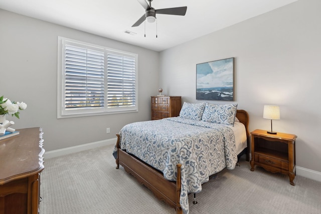 carpeted bedroom featuring a ceiling fan, visible vents, and baseboards