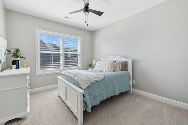 bedroom with light carpet, a ceiling fan, visible vents, and baseboards