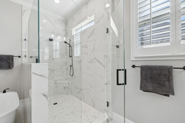 full bath with a freestanding tub, a marble finish shower, and crown molding