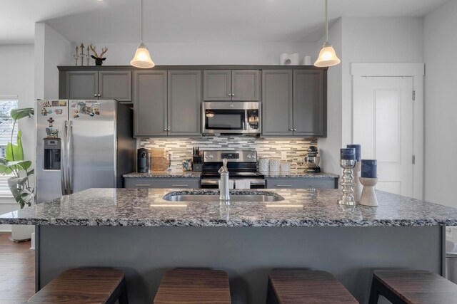 kitchen featuring appliances with stainless steel finishes, decorative backsplash, and gray cabinetry