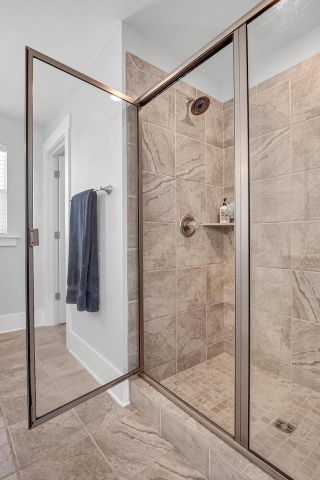 bathroom featuring a stall shower and baseboards