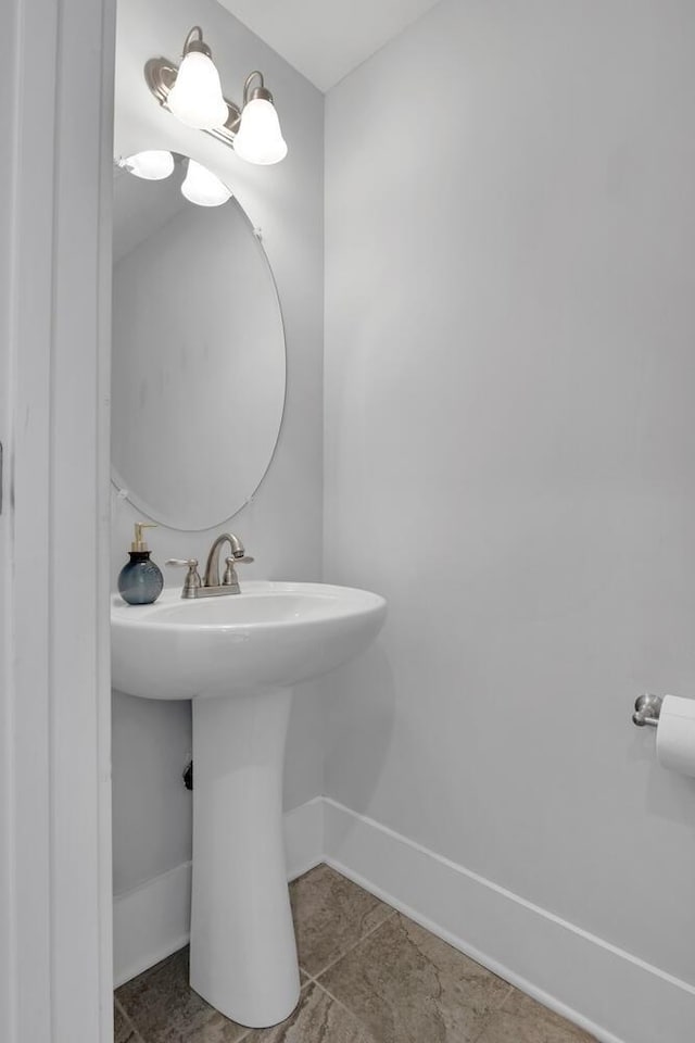 bathroom with tile patterned flooring, a sink, and baseboards