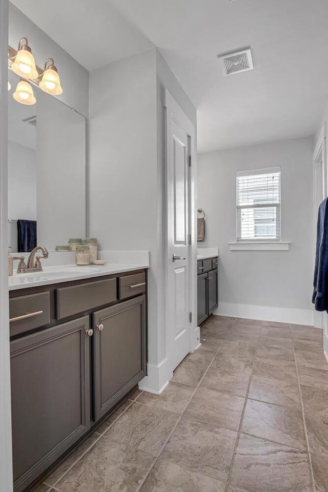 bathroom featuring vanity, visible vents, and baseboards