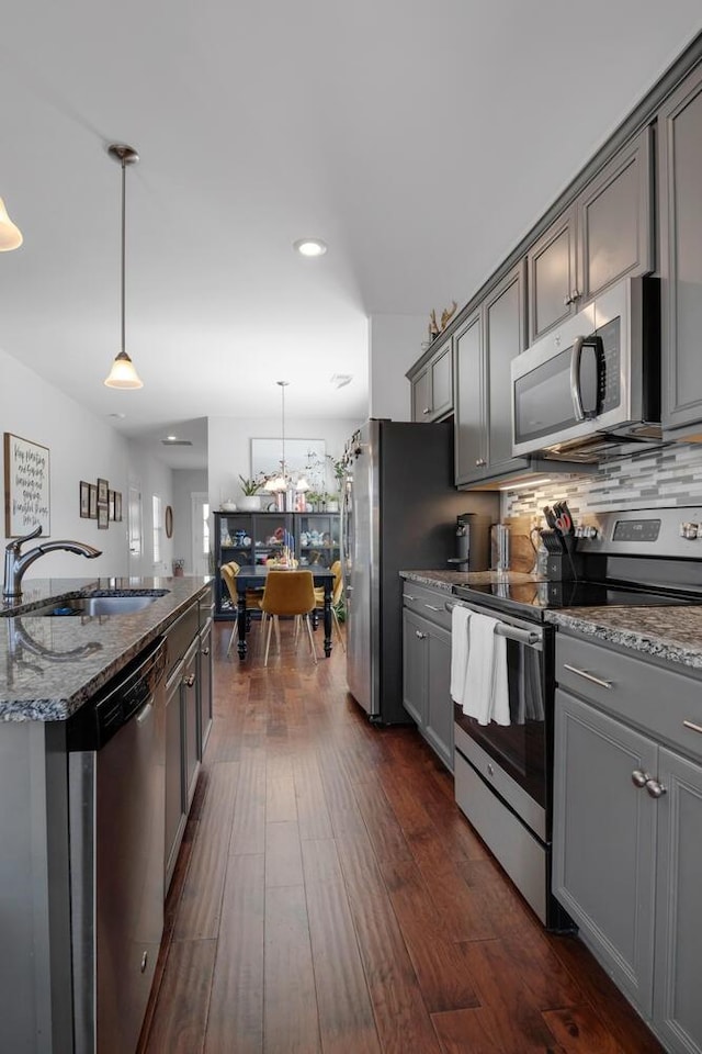 kitchen featuring dark wood-style floors, appliances with stainless steel finishes, a sink, and gray cabinetry