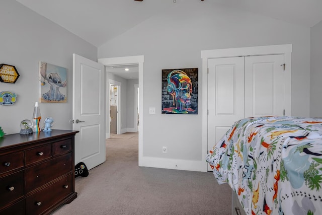 bedroom with vaulted ceiling, a closet, light carpet, and baseboards