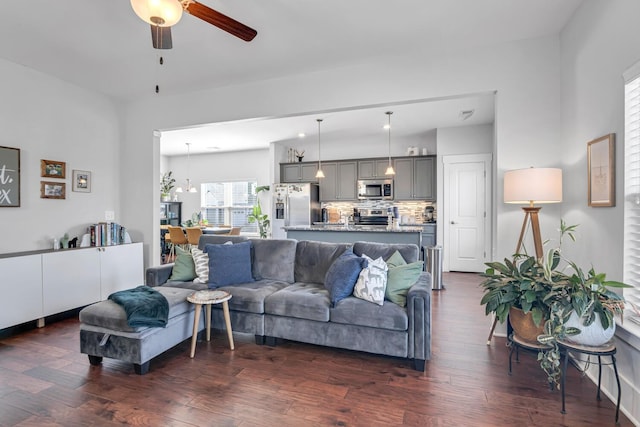 living room featuring ceiling fan and dark wood finished floors