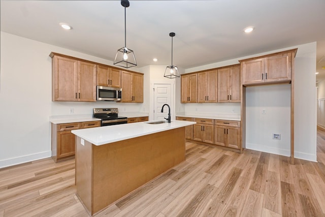 kitchen featuring baseboards, light countertops, appliances with stainless steel finishes, light wood-style floors, and a sink