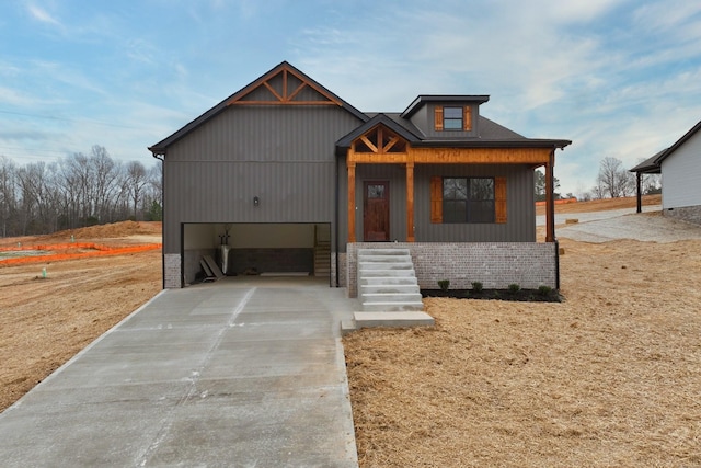 view of front of house featuring concrete driveway, brick siding, and a garage