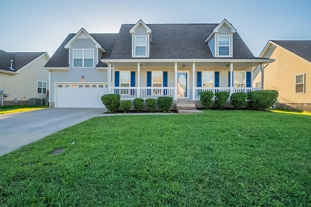 view of front facade featuring a porch, an attached garage, cooling unit, concrete driveway, and a front lawn