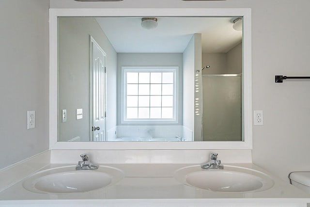 full bathroom featuring a sink, toilet, and double vanity