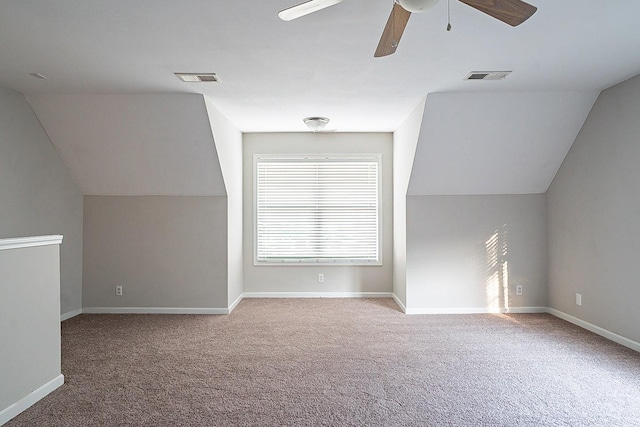 additional living space featuring carpet floors, visible vents, vaulted ceiling, and baseboards