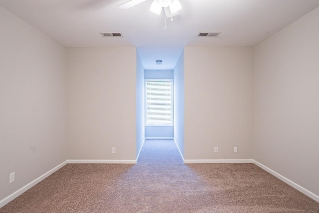 unfurnished room with carpet, visible vents, ceiling fan, and baseboards