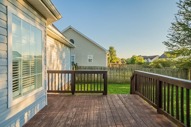 wooden deck featuring a lawn and fence private yard