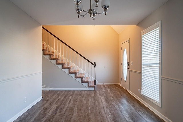 entrance foyer featuring an inviting chandelier, stairway, baseboards, and wood finished floors