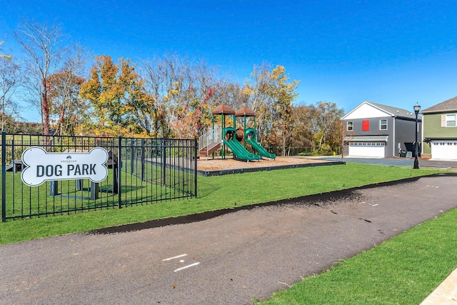 communal playground featuring fence and a lawn