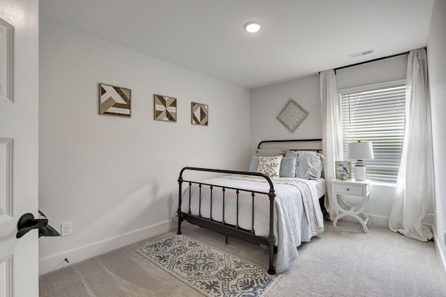 carpeted bedroom featuring visible vents and baseboards