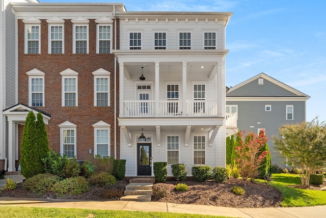 view of front of house featuring brick siding and a balcony