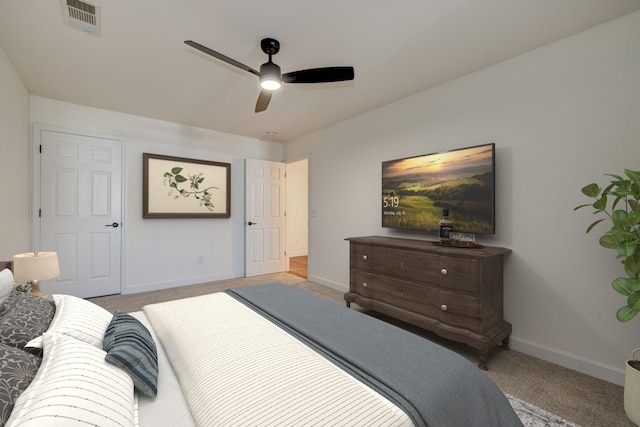 carpeted bedroom featuring a ceiling fan, visible vents, and baseboards