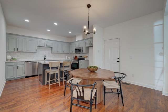 dining room featuring a notable chandelier, recessed lighting, wood finished floors, visible vents, and baseboards