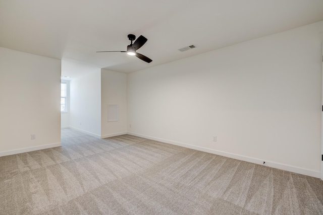 unfurnished room with baseboards, ceiling fan, visible vents, and light colored carpet