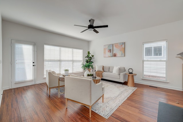 living room with ceiling fan, wood finished floors, and baseboards